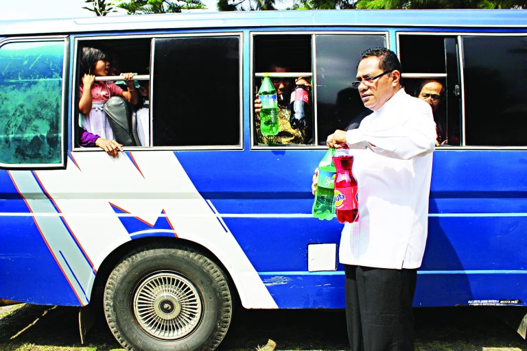 Ketua I MS, Pdt Martinus Tetelepta membagikan minuman ringan kepada warga Pos Pelkes.